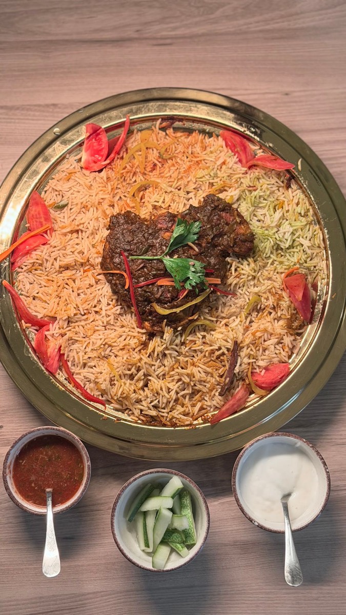 Charcoal-grilled chicken in a rich dark masala on Mandhi rice